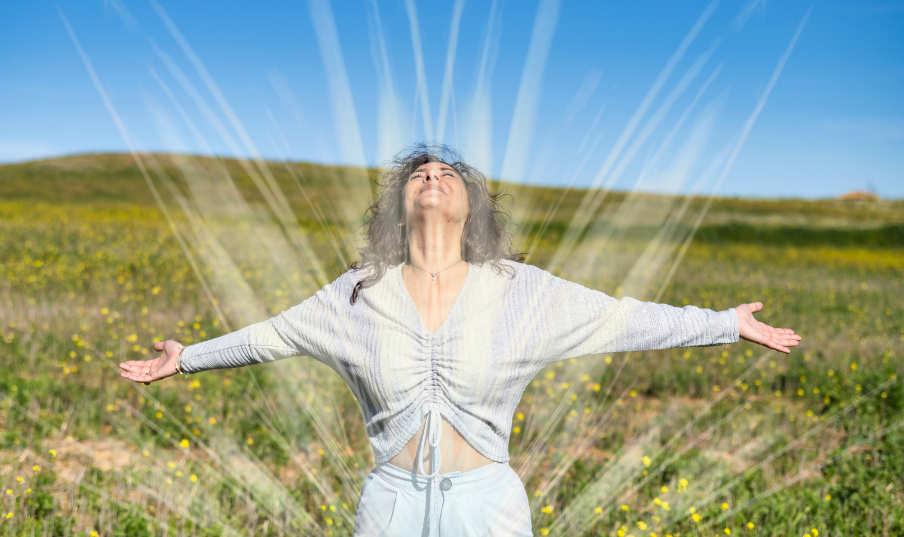 Kobieta z rozpostartymi ramionami podczas wiosennego oczyszczania biopola na tle wiosennej łąki